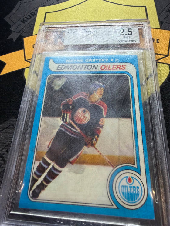 A graded 1979-80 Topps Wayne Gretzky card before cleaning, its case heavily scratched and hazy